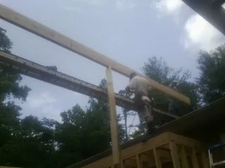 Carpenter setting a ridge beam over a new addition frame — Ice Dam Removal by Roofing Brothers in Mauston