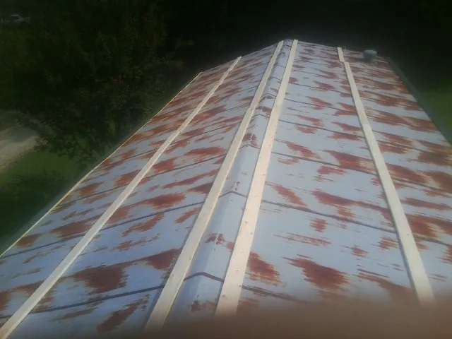 Rusted metal roof panels with new wood purlins before replacement — Storm Damage Roof Repair in Mauston by Roofing Brothers